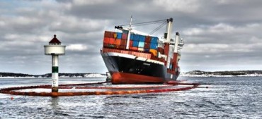 The rescue team in their attempt to contain an oil spill © Foto Kystverket