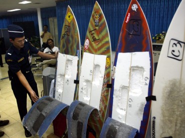A Customs officer inspects surfing boards used by Brazil's citizen Rodrigo Gularte to smuggle 6 kilograms of cocaine in 2004 (AP Photo/Dita Alangkara)