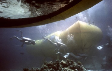 The divers from Cousteau's team are leaving the yellow saucer to access "Denise", the underwater habitat © The Cousteau Society