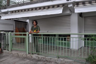 Eric Pinault stands in front of his old surf shop in Étang-Salé. The blinds have been closed for a long time. © Andy Guinand / OCEAN71 Magazine