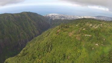 The steep slopes of Reunion Island are covered in lush vegetation. 40% of the territory is UNESCO protected. In the background, Saint-Denis, the capital. © Andy Guinand / OCEAN71 Magazine