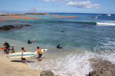 During an exercice at the Roches Noires beach, all of the Vigies Requin Renforcées program can be seen. In the background, the various boats assist the operations. The smoke bombs warn against a danger. The pairs of vigies bring the surfers back to shore and secure the area © Jo Besson / VRR